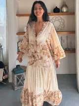 Vestido largo de estilo campesino con estampado de palmeras en tonos blanco y negro, con escote en V y mangas largas abullonadas.
