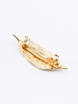Broche con forma de hoja color dorado.