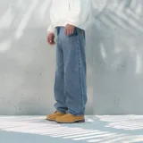 Pantalón jean de denim azul claro, corte amplio tipo baggy con bolsillos delanteros y traseros.