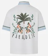Camisa masculina de algodón con corte boxy, cuello con solapa y rayas, abotonado delantero, bolsillo con estampa floral y estampa trasera de palmera con la palabra 'Paradise'.