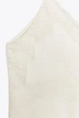 Top color crema de Zara Woman Collection, con escote pico, tirantes finos ajustables y detalle de encaje a tono.