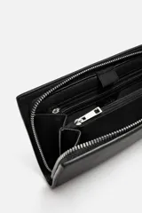 Bandolera negra rectangular con textura grabada. Tiene un compartimento principal con cierre de cremallera, un bolsillo interior con cremallera y un bolsillo simple. El asa de hombro es ajustable y extraíble.
