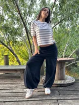 Blusa color beige de viscosa elastizada, con cuello bote y espalda cruzada. Estampado frontal con ilustración de una cara con corona de flores.