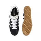 Championes Adidas Gazelle negros con las tres tiras laterales blancas y detalles dorados.