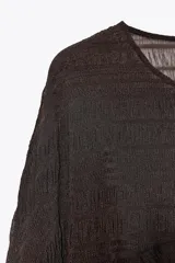 Top marrón con cuello redondo y manga larga tipo capa. Detalle de tejido con textura y bajo asimétrico.