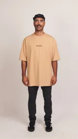 Remera beige de jersey de algodón con cuello redondo y corte oversize. Estampa frontal con la palabra 'RUFIÁN' en marrón.