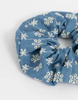 Maxi scrunchie de denim celeste con detalles de flores bordadas en blanco.