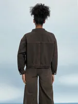 Campera de jean celeste con efecto lavado, corte cropped, cuello clásico, cierre frontal con botones metálicos, cuatro bolsillos frontales con solapa y puños abotonados.