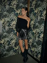Top negro de gasa con escote off-shoulder y mangas largas abullonadas con elástico.