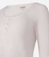 Conjunto de pijama femenino compuesto por una blusa de manga larga color rosa pálido con escote redondo y tres botones decorativos, y un pantalón largo con estampado de corazones grandes verdes y rosados sobre fondo blanco.