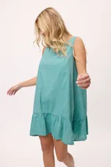 Vestido blanco de lino y algodón, corte suelto, con volados en el ruedo y escote bote.