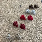 Aros cortos con forma de racimo de uvas, hechos de cristales facetados color borgoña. Cierre a presión.