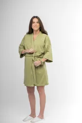 Bata corta color verde oliva, estilo kimono, confeccionada en algodón con textura acanalada. Tiene mangas 3/4, cuello en V cruzado y lazo para ajustar en la cintura.