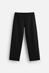 Pantalón jogger negro de corte recto, confeccionado en tejido de algodón compacto con interior en rizo. Cuenta con cintura elástica ajustable con cordón interior, bolsillos frontales y bolsillo de doble vivo en la espalda.