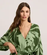 Vestido evasé midi de mangas amplias, confeccionado en viscosa, con escote en V, elástico y lazo en la cintura y estampado de follaje en tonos verdes.