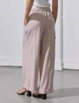 Pantalón de lino color rosa pálido, de corte ancho, con pretina elastizada, lazo de ajuste y bolsillos cargo laterales.