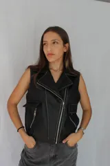 Chaleco marrón de cuero sintético con cuello solapa, cierre frontal asimétrico con cremallera, bolsillos con cremallera y corte ajustado.