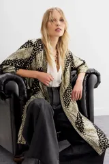 Kimono de viscosa con jacquard en lurex, calce recto y mangas largas. Presenta guarda bordada en el frente con apliques e interior en jacquard.