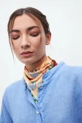 Pañuelo cuadrado pequeño de seda estampada con motivos marinos en tonos beige, celeste, marrón y verde.