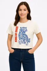 Remera color crudo de corte cropped, con cuello redondo y mangas cortas. Estampado frontal con un tigre azul y la frase "King of Power" en rojo.