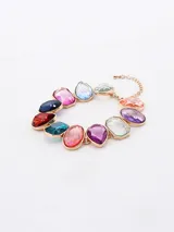 Set de cuatro anillos dorados con piedras de colores: rosa, verde, rojo y azul.