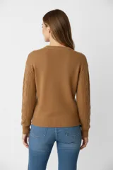 Sweater de punto acrílico azul, con diseño de punto trenzado en el frente y mangas, cuello redondo y calce holgado.