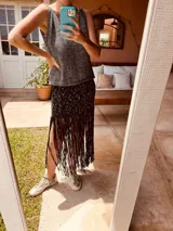 Falda negra tejida en lurex con flecos y detalles en crochet.