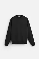Sudadera negra de corte holgado, cuello redondo y mangas largas con puños acanalados.