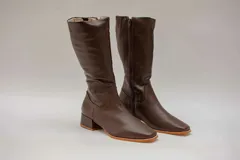 Bota de caña media de cuero color marrón chocolate, con puntera cuadrada, cierre lateral y taco cuadrado bajo.