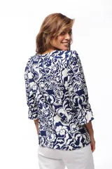 Blusa estampada azul y blanca con escote en V, mangas 3/4 con volados y cierre frontal con botones.