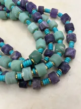 Collar de cuentas de piedra natural en tonos verde y lila, intercaladas con cuentas turquesas y detalles dorados.
