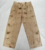 Pantalón de lino color beige con estampado abstracto en tonos marrones y rojizos, tiro alto, corte holgado, pinzas en la cintura y bolsillos laterales.