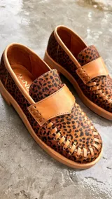 Mocasines con estampado animal print, detalle de cuero liso en la parte superior y suela color caramelo.