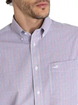 Camisa de hombre celeste a rayas verticales azules, de corte regular, con cuello abotonado, bolsillo en el pecho con logo bordado y mangas largas con puños abotonados.