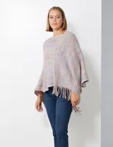 Poncho de tejido suave, color crudo con hilos multicolores que generan un efecto jaspeado en tonos pastel (rosa, celeste, lila). Presenta un diseño asimétrico con cuello redondo y terminación en flecos largos en el ruedo.