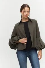 Camisa negra con cuello clásico y mangas largas con detalle de volados en los puños.