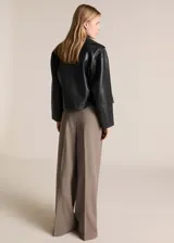 Chaqueta negra efecto piel con cuello de solapa, cierre cruzado con doble botonadura, corte crop y diseño oversize.
