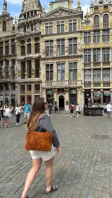 Bolso de mano o de hombro, tipo bowling o doctor bag, de color azul marino. Confeccionado en gamuza con un gran logo bordado en azul más claro en el frente. Posee dos asas trenzadas de cuero.