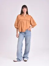 Blusa color beige con cuello mao, escote en V y mangas 3/4 con elástico en los puños.