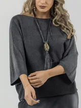 Collar largo con cordones de cuero sintético negro y dije colgante con forma de jaula dorada y flecos.