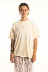 Remera verde militar con efecto gastado, corte oversize y estampado frontal con logo circular en color crudo.