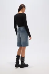 Bermuda de jean azul claro, estilo boyfriend, tiro alto, con largo a la rodilla y roturas.