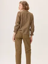 Jean recto de gabardina color marrón/camel, con pespuntes contrastantes en color negro. Presenta un detalle de atraque rojo en el bolsillo trasero.