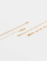 Set de dos collares dorados: uno corto de perlas sintéticas con dije de corazón dorado y otro largo con cadena de eslabones y dijes de corazones.