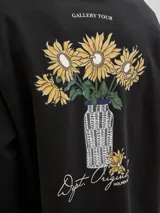 Buzo negro de manga larga con cuello redondo, fit oversize y estampa en la espalda con dibujo de flores en un jarrón.