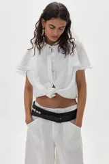 Cinturón negro de cuero vacuno con detalle de caracoles aplicados, hebilla forrada y diseño trenzado.