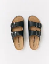 Sandalias Freeway con dos tiras negras ajustables con hebilla metálica y plantilla marrón.