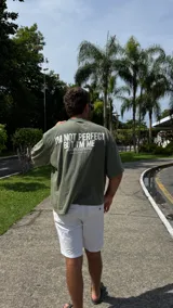 Remera verde militar de corte boxy con cuello redondo y estampado frontal con la frase "I'm not perfect but I'm limited edition".