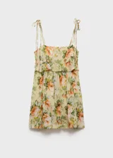Vestido corto de gasa color amarillo pálido con estampado de rosas anaranjadas y hojas verdes. Tiene escote recto con volantes, tirantes finos y cierre lateral con cremallera.