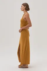 Top halter tejido texturizado en tono mostaza con tiras finas que se atan en la espalda.